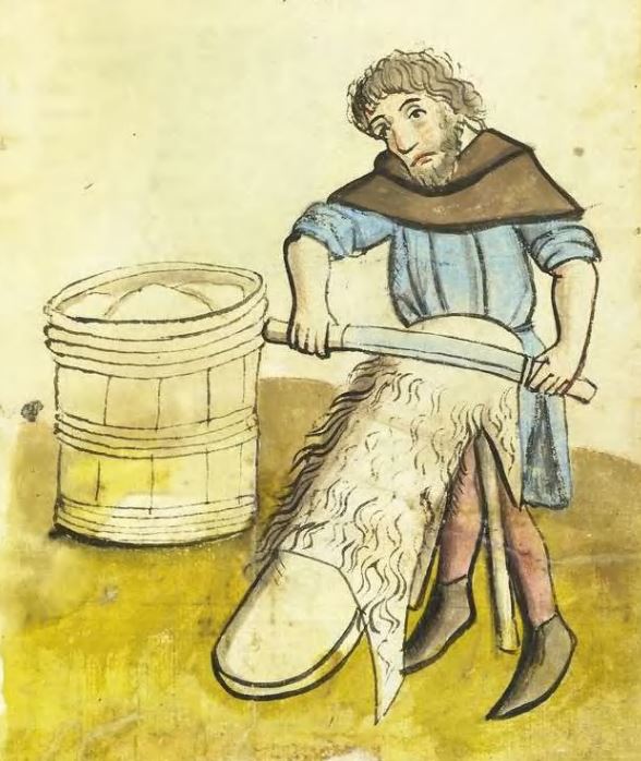 Un artisan gratte une peau posée sur un chevalet